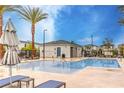 Community pool with lounge chairs and palm trees on a sunny day at 1267 Dorado Sea Ct, Henderson, NV 89052