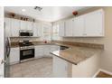 Well-lit kitchen features stainless steel appliances, granite countertops, wood-style ceramic flooring, and bright white cabinets at 1813 Arch Stone Ave, North Las Vegas, NV 89031