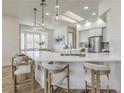 Bright, modern kitchen with bar seating, pendant lighting, stainless steel appliances, and skylight at 1964 Oliver Springs St, Henderson, NV 89052