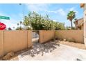 Backyard patio with block fence, metal gate, and desert landscaping at 2261 Tall Pine Dr, Las Vegas, NV 89108