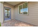 Enclosed patio area featuring brick pavers, exterior door, and large window at 240 White Crest Peak Ave, Henderson, NV 89015