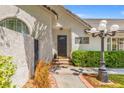 Inviting entryway with a decorative front door, lush greenery, and charming outdoor lighting at 2513 Aberdeen Ln, Henderson, NV 89014