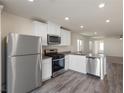 Modern kitchen featuring stainless steel appliances, white cabinetry, and a functional island for meal prep at 2728 Pavehawk Way, Las Vegas, NV 89156