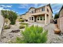 Home backyard with small trees, bushes, rocks, and artificial grass at 3624 Pelican Brief Ln, North Las Vegas, NV 89084