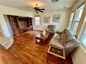 Spacious living room featuring a ceiling fan, wood floors and large windows at 3624 Pelican Brief Ln, North Las Vegas, NV 89084