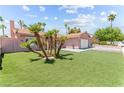 Spacious backyard with well-maintained artificial lawn, mature palm trees, and privacy fencing at 4115 Ridgewood Ave, Las Vegas, NV 89120