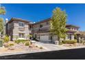 Stylish two-story home with a three-car garage, desert landscaping, and a well-manicured yard at 437 Pinnacle Heights Ln, Las Vegas, NV 89144