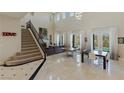 Spacious living room featuring a staircase, fireplace, tile floors, and natural light at 437 Pinnacle Heights Ln, Las Vegas, NV 89144