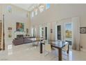 Open living room with fireplace, high ceilings, natural light, tile floors, and dining area at 437 Pinnacle Heights Ln, Las Vegas, NV 89144