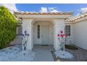 Charming front entrance with decorative metal flowers and arched doorway at 4644 Canna Dr, Las Vegas, NV 89122