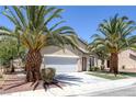 Inviting single-story home featuring desert landscaping with mature palm trees and an attached two-car garage at 5213 Giallo Vista Ct, North Las Vegas, NV 89031