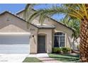Inviting single-story home featuring desert landscaping with mature palm trees and an attached two-car garage at 5213 Giallo Vista Ct, North Las Vegas, NV 89031