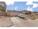 Single-story home featuring a large garage, car in the driveway, and gravel landscaping at 604 N Torrey Pines Dr, Las Vegas, NV 89107
