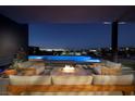 Inviting outdoor patio features a cozy fire pit and comfortable seating with views of the pool and city lights at 609 Sleeping Dragon Dr, Henderson, NV 89012