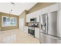 Well-lit kitchen area with stainless steel appliances, tile floors, and classic chandelier at 8541 Highland View Ave, Las Vegas, NV 89145