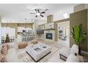 Open-concept living room featuring a fireplace, ceiling fan, and ample natural light at 8541 Highland View Ave, Las Vegas, NV 89145