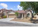 Inviting single-story home with a well-maintained desert landscape, beautiful arches and a tile roof at 1006 Cove Palisades Dr, North Las Vegas, NV 89031