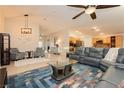 Inviting living room with tile floors, a modern ceiling fan, and stylish furniture creating a comfortable space at 10243 Cowboys Dream St, Las Vegas, NV 89131