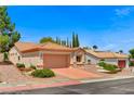 Inviting home features desert landscaping, terra cotta roof, and a two-car garage at 10636 Argents Hill Dr, Las Vegas, NV 89134