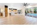 Spacious living room featuring light wood floors and multiple sliding glass doors with a view of a swimming pool at 10668 Porta Romana Ct, Las Vegas, NV 89141