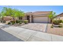 Charming single-story home with a well-maintained front yard, mature trees and a paved driveway leading to a two-car garage at 1081 Via Gandalfi, Henderson, NV 89011