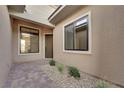 Inviting entryway featuring tile flooring, neutral stucco exterior, and modern landscaping elements at 11049 Concord Valley Drive, Las Vegas, NV 89135