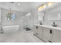 Bright bathroom featuring a double vanity, soaking tub, walk-in shower with glass enclosure, and modern lighting at 1109 Maserati Dr, Las Vegas, NV 89117