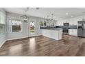 Open-concept kitchen and dining area with granite countertops, stainless appliances, and hardwood floors at 1109 Maserati Dr, Las Vegas, NV 89117