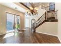 Spacious living room showcasing hardwood floors, elegant staircase, and a stylish chandelier, filled with natural light at 11228 Hedgemont Ave, Las Vegas, NV 89138