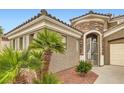Mediterranean entrance with an arched stone portico, metal gate and tropical landscaping at 11278 Tenza Ct, Las Vegas, NV 89141