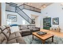 Spacious living room featuring hardwood floors, a staircase, and a comfortable sectional sofa at 11278 Tenza Ct, Las Vegas, NV 89141