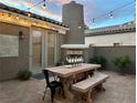 Outdoor patio with a wooden table and chairs, fireplace, string lights, and tiled flooring, perfect for entertaining at 11278 Tenza Ct, Las Vegas, NV 89141