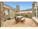 Outdoor patio area with fireplace, tile flooring, and wooden dining table at 11278 Tenza Ct, Las Vegas, NV 89141