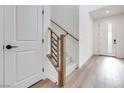 Bright entryway featuring wood-look floors and a staircase with black metal railings at 11946 Glide Reflection Ave, Las Vegas, NV 89138