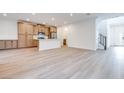 Open-concept living space with wood-look floors adjacent to a kitchen at 11946 Glide Reflection Ave, Las Vegas, NV 89138