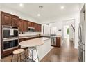 Modern kitchen featuring stainless steel appliances, granite countertops, an island, and dark wood cabinets at 1887 Hollywell St, Las Vegas, NV 89135