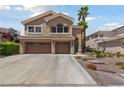 Charming two-story home features a three-car garage, desert landscaping, and a walkway to the front door at 2113 Waterbury Ln, Las Vegas, NV 89134