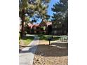 Well-manicured lawn and shady trees surround this condominium building with a walkway, BBQ, and picnic area at 2200 S Fort Apache Rd # 2062, Las Vegas, NV 89117