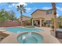 Backyard showcasing a refreshing pool and spa, complemented by a covered patio and mature trees at 2445 Rue Royale, Henderson, NV 89044