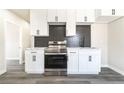 Modern kitchen with white cabinets, stainless steel appliances, dark backsplash, and countertops at 266 Tungsten St, Henderson, NV 89015