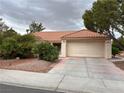 Lovely single-story residence showcasing a terracotta roof, two-car garage, and beautifully landscaped front yard at 2801 Golfside Dr, Las Vegas, NV 89134