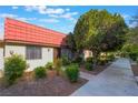 Inviting single-story home with a red tile roof, surrounded by lush landscaping at 3925 Torsby Pl, Las Vegas, NV 89119