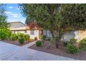 View of the home's exterior with a red tile roof and mature landscaping at 3925 Torsby Pl, Las Vegas, NV 89119