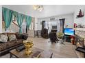 Spacious living room with wood look floors, fireplace, ample seating, and bright natural light from the front windows at 4602 Inland Ct, Las Vegas, NV 89147