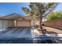 Single story home with a covered carport, mature shade tree, desert landscaping, and a brick border at 4735 Roby Grey Way, North Las Vegas, NV 89081