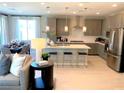 Open-concept kitchen featuring gray cabinets, stainless steel appliances, a large island, and seamless flow to the dining area at 6511 Dove Point Pl, Las Vegas, NV 89130