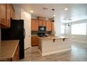 Modern kitchen features wood-style floors, sleek black appliances, and dining area at 7715 Peaceful Trellis Dr, Las Vegas, NV 89179