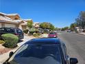 Neighborhood street view with well-maintained townhomes, mature trees, and parked cars at 8072 Cimarron Ridge Dr # 201, Las Vegas, NV 89128