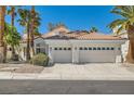 Charming home exterior featuring a two-car garage and well-manicured landscaping with palm trees at 8124 Bay Harbor Dr, Las Vegas, NV 89128