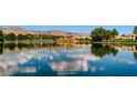 Scenic community lake reflecting the blue sky and architecture beyond with lush trees and landscaping at 8124 Bay Harbor Dr, Las Vegas, NV 89128